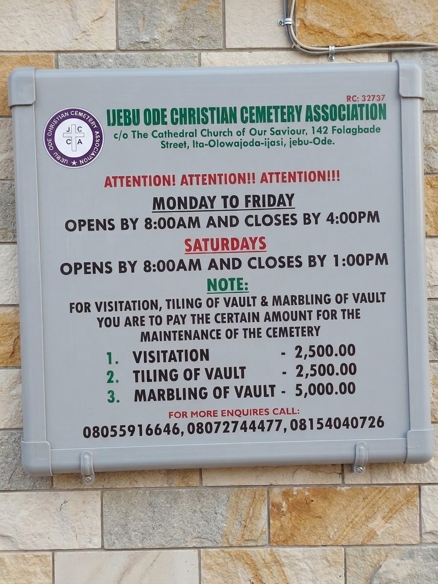 Official notice board posted at the cemetery entrance listing hours and fees